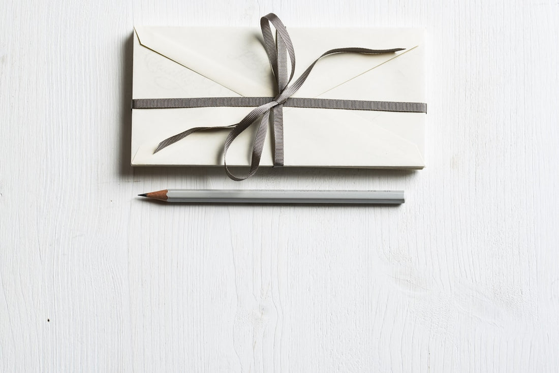 Schön verpacktes Geschenk mit Band und Bleistift – ein handgebundenes Notizbuch verschenken