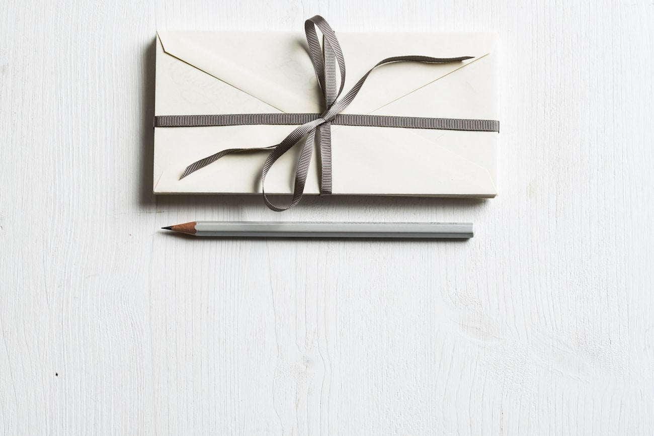Schön verpacktes Geschenk mit Band und Bleistift – ein handgebundenes Notizbuch verschenken