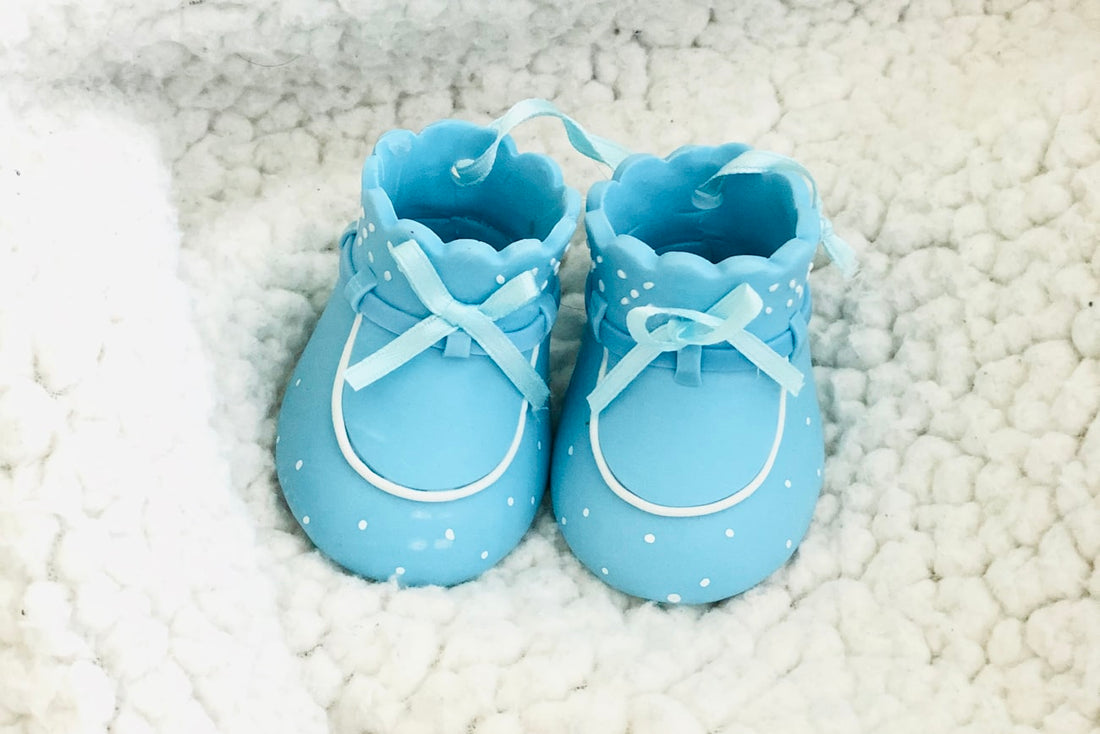 Hellblaue Babyschuhe auf einer weichen Decke – Erinnerungen ans erste Jahr