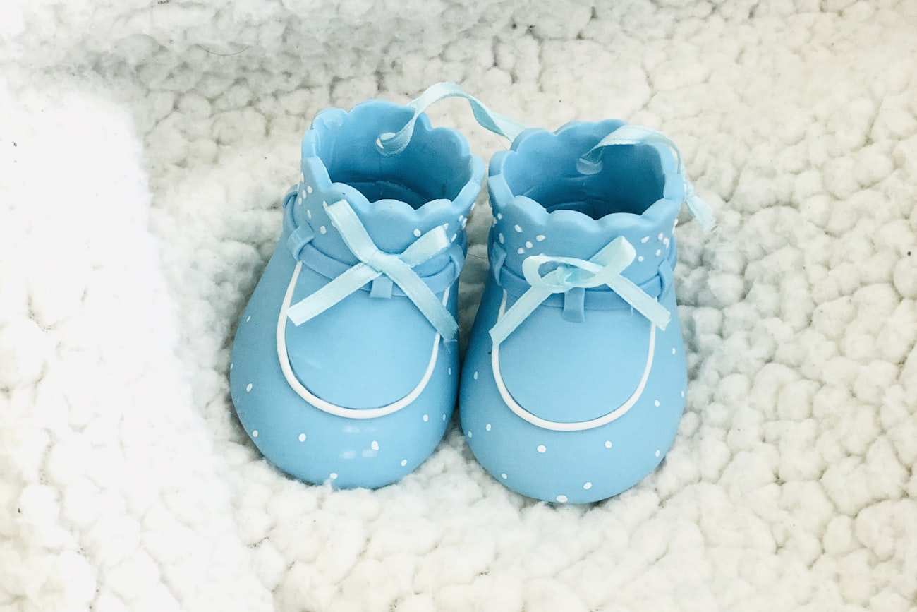 Hellblaue Babyschuhe auf einer weichen Decke – Erinnerungen ans erste Jahr